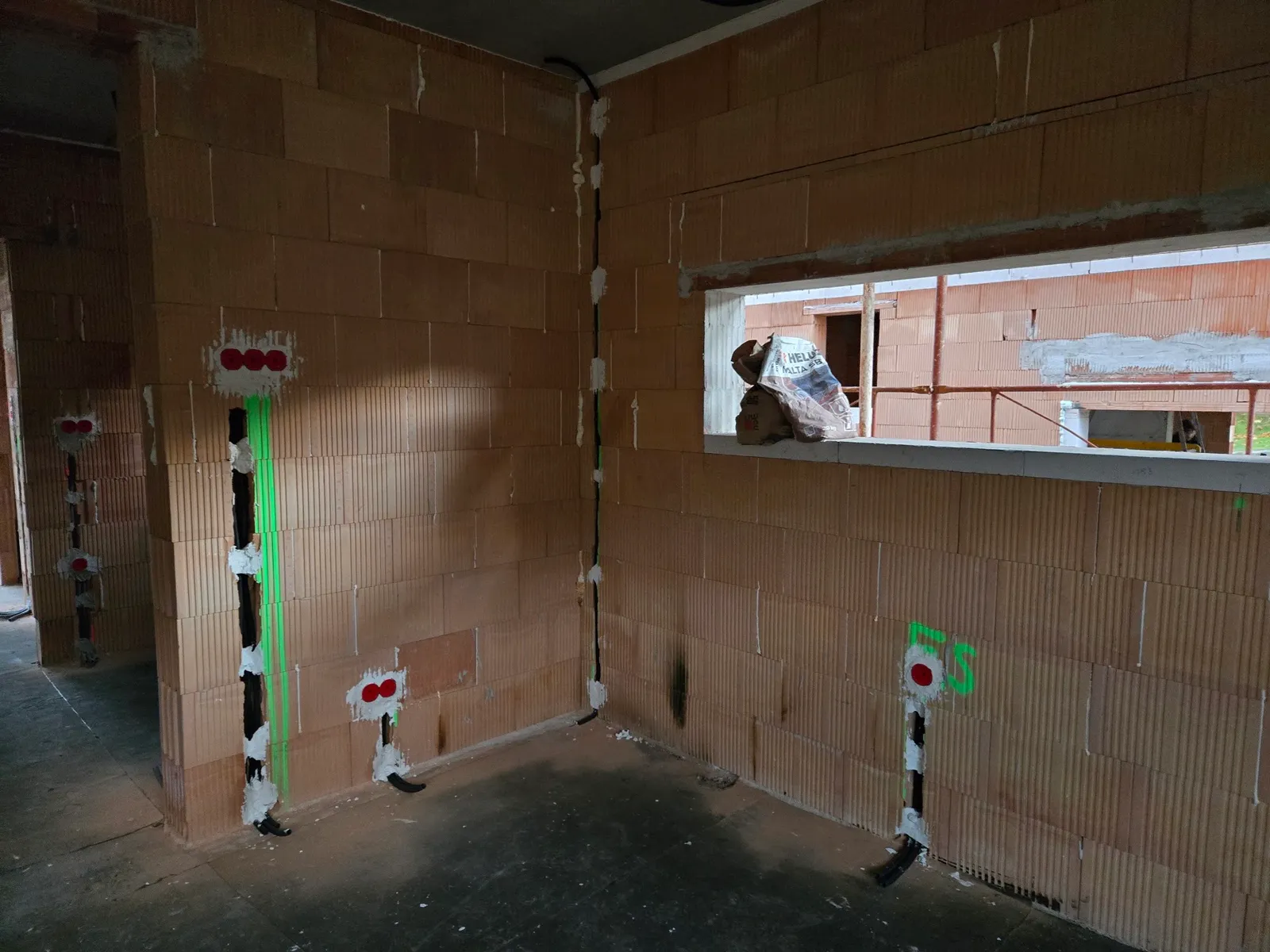 Rohbauinstallation mit sauber verlegten Leerrohren im Ziegelmauerwerk