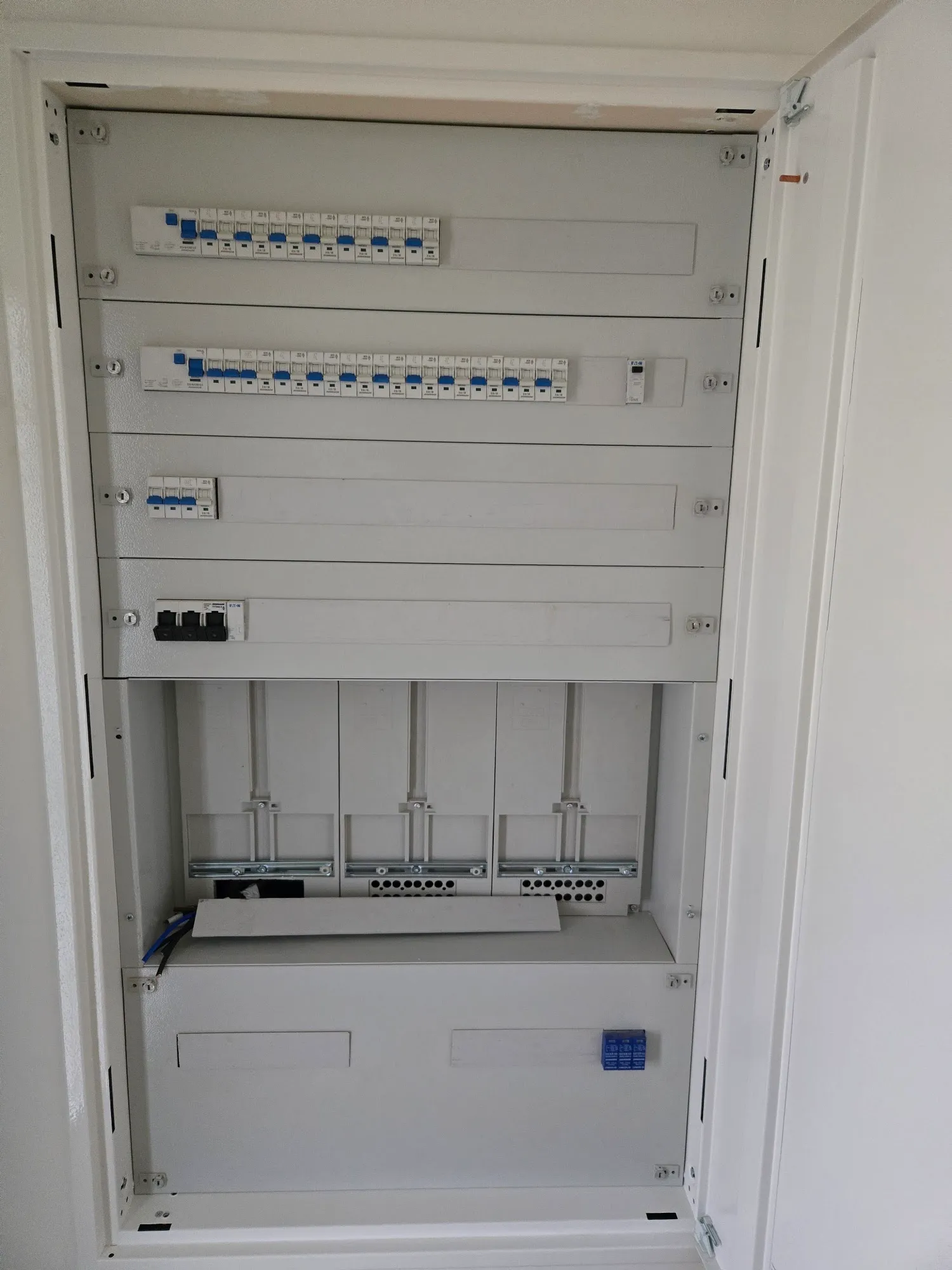 Großer Unterputz-Verteilerschrank mit montierten Hutschienen und Zählerplatz